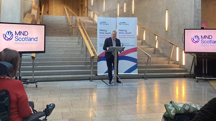 Bob Doris MSP inside the Scottish Parliament speaking at the MND Scotland awareness event.